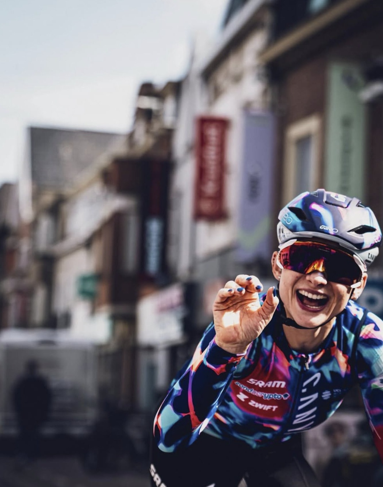 Coureuse Canyon-SRAM saluant avec joie dans une rue