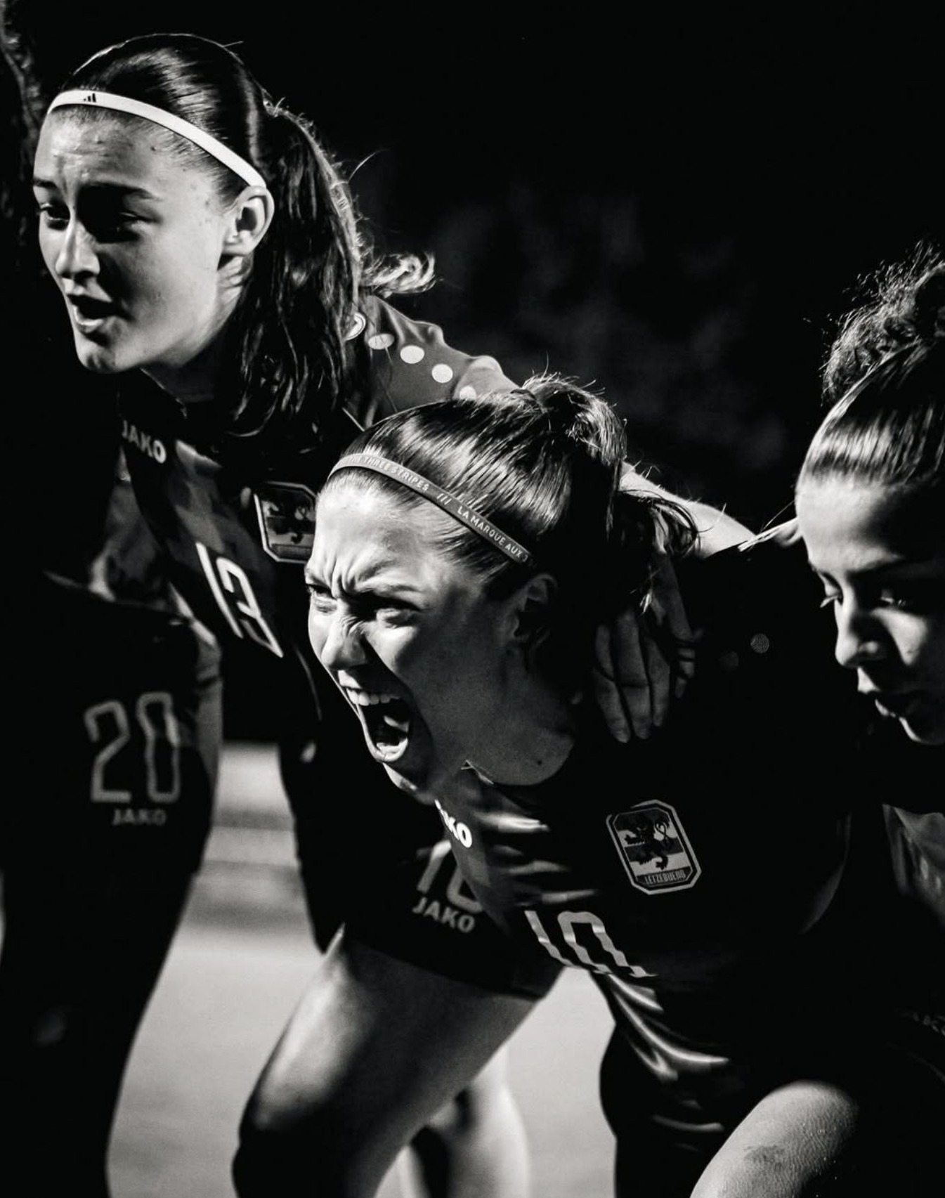 Footballeuses criant de rage collective après un but, noir et blanc nocturne
