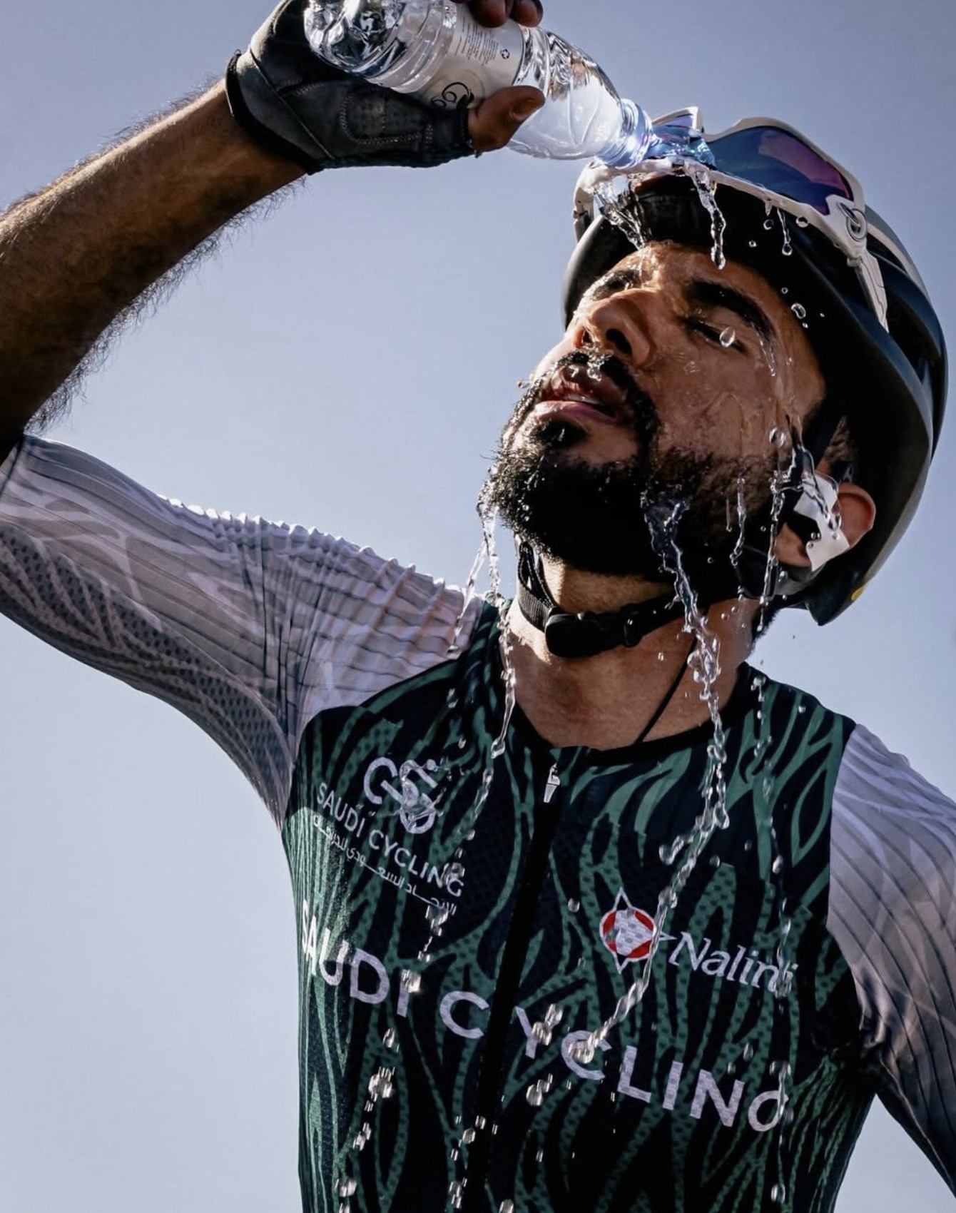 Coureur saoudien s'aspergeant d'eau par la chaleur