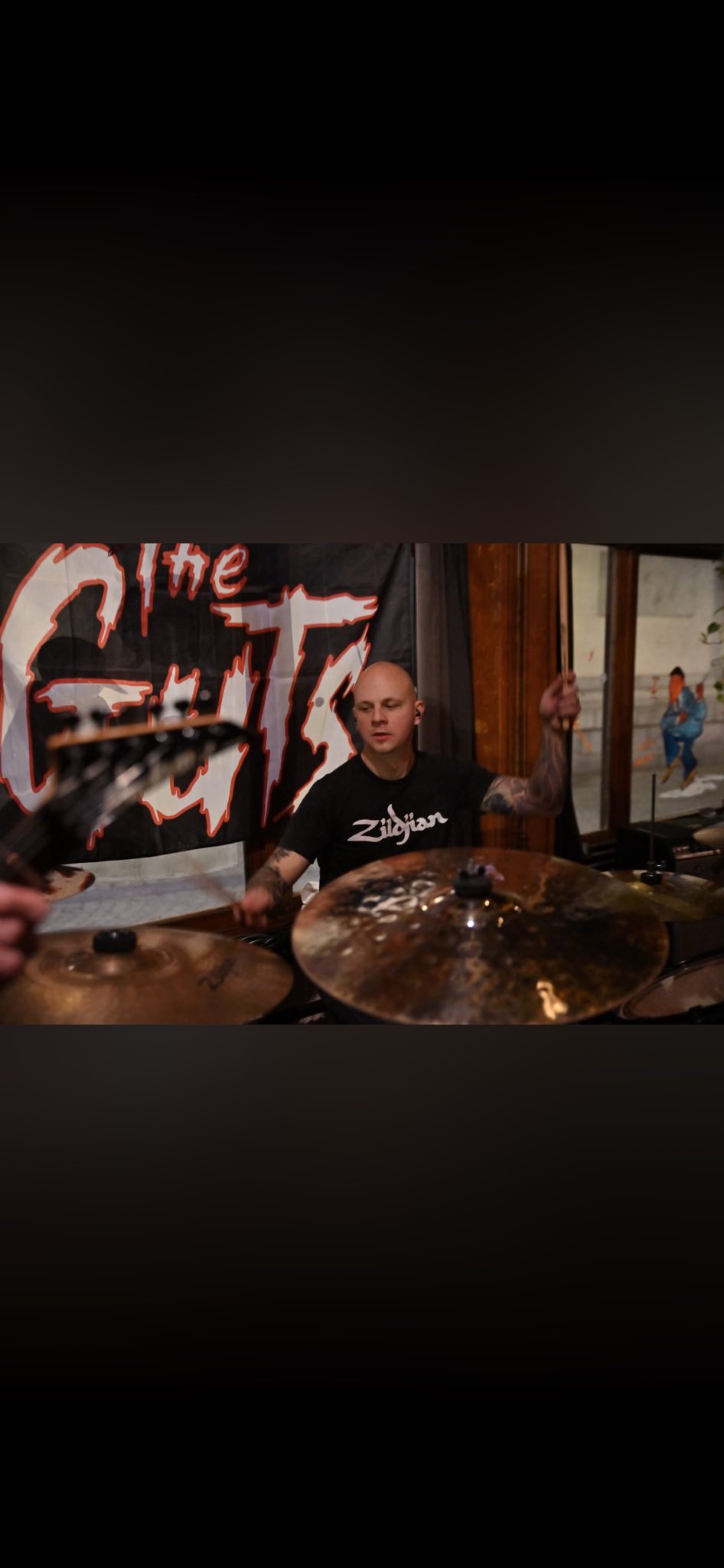 Kenny devant le backdrop The Guts